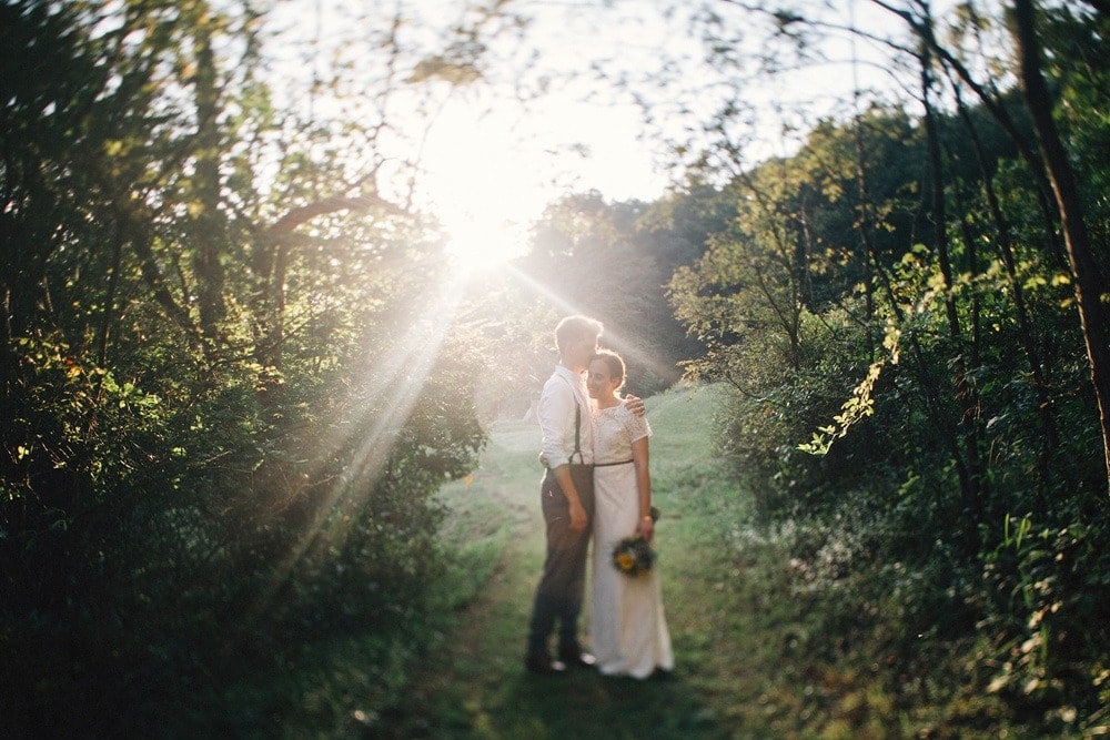 married couple at sunset in rainbow lens flare