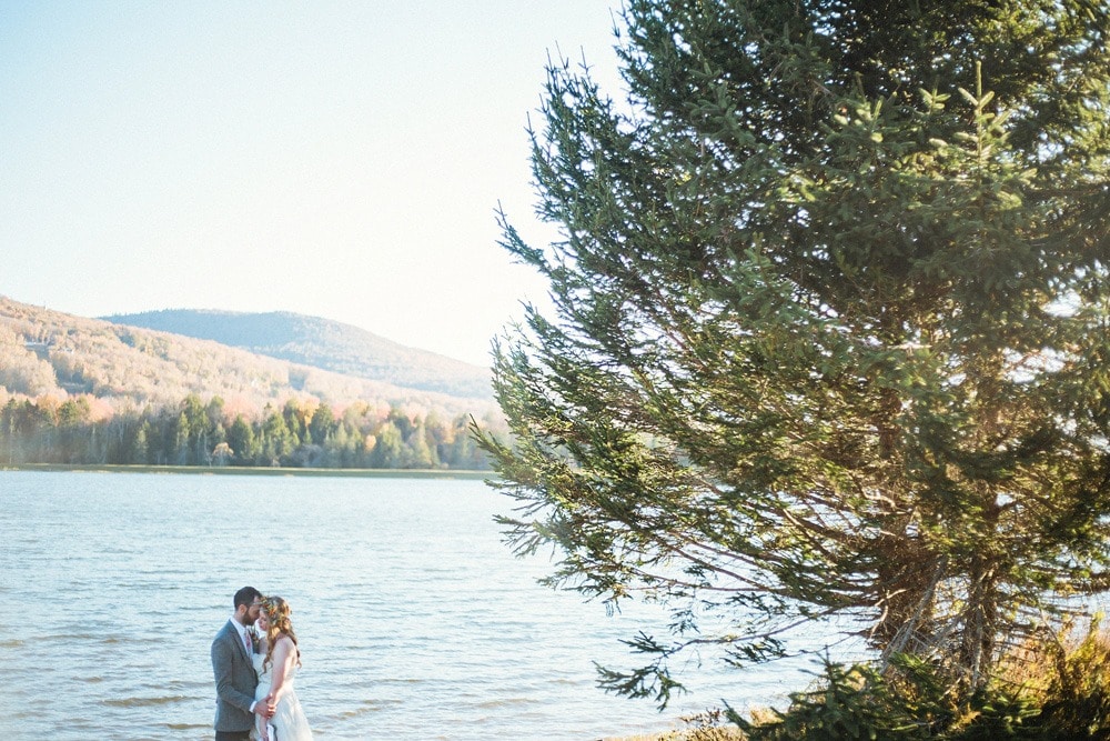 wedding couple by water and tree